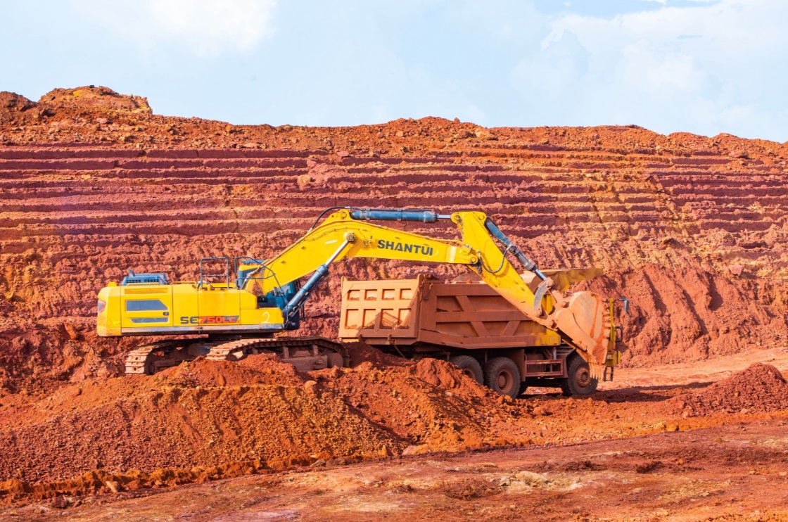 Excavator loading ore on terraced benches