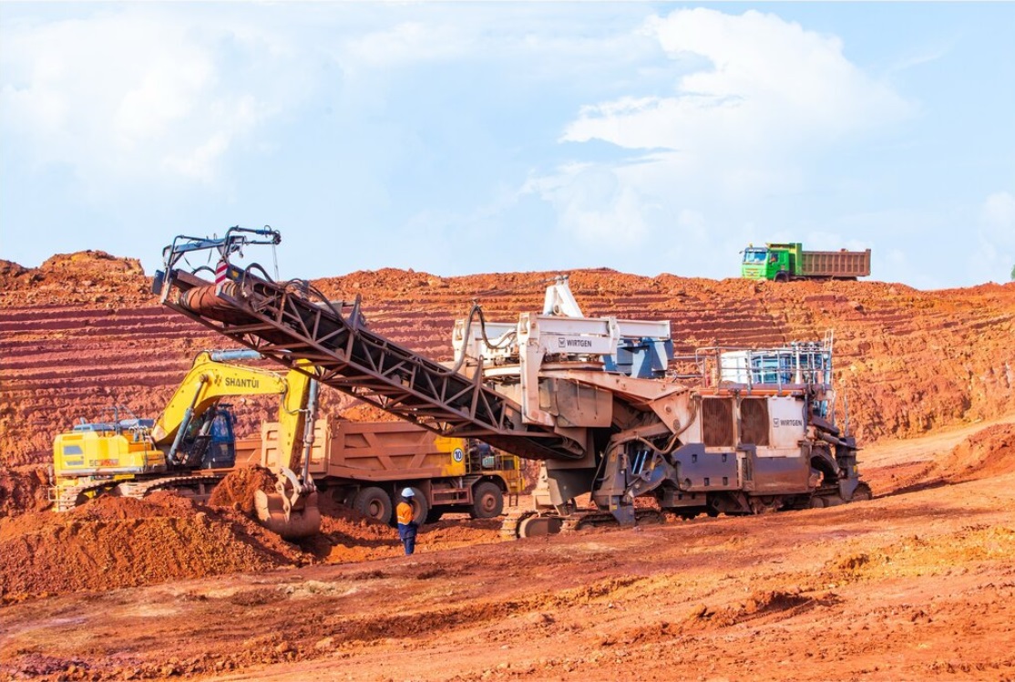 Surface miner and excavator loading trucks